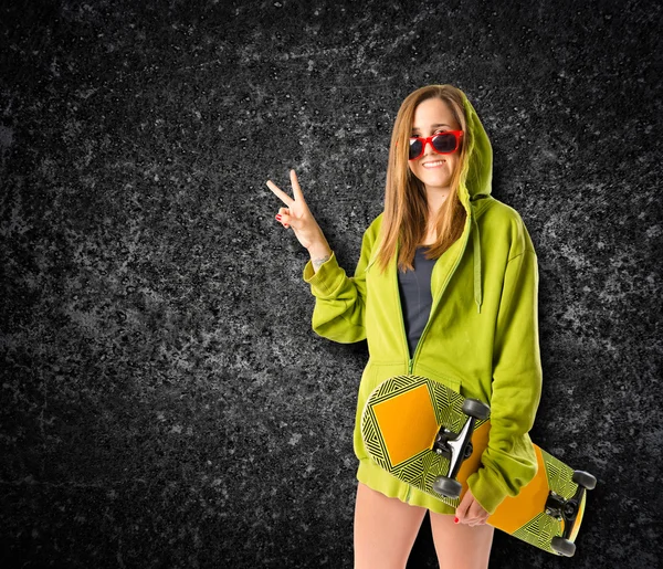 Young girl doing victory gesture over black background