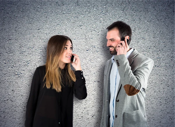 Couple talking to mobile  over textured background