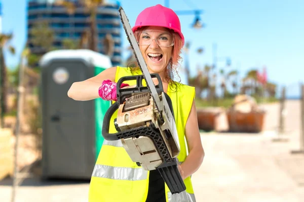 Worker woman with chainsaw over white background