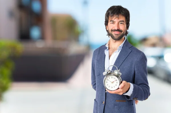 Businessman holding a clock over white background