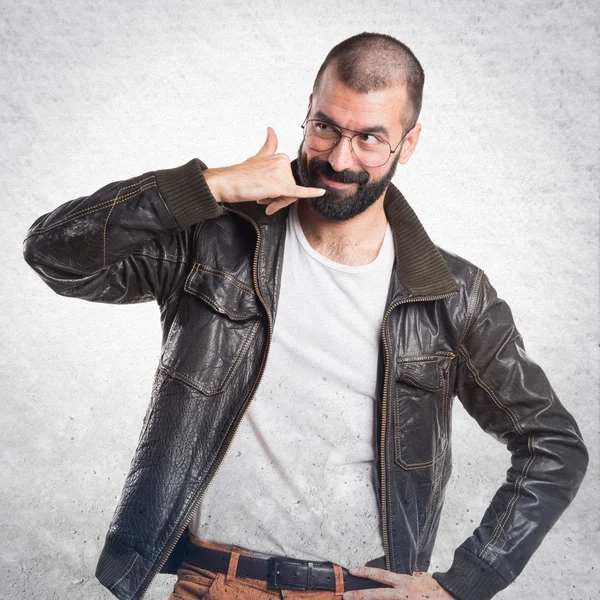Man with leather jacket making phone gesture