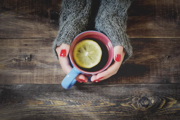 Tea with lemon, hand in sweater. Top view