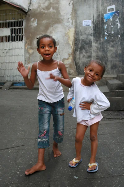 Two black African girls play on the street Stone Town.