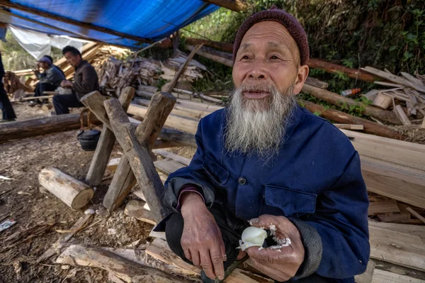 Langde Shang Miao Village, Old chinese man eating chicken egg.