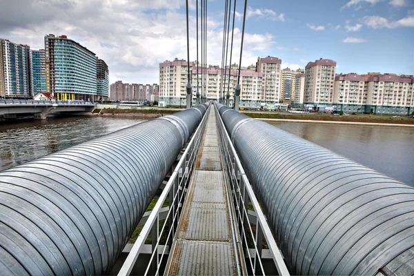 Heating duct crosses river on cable-stayed bridge in residential