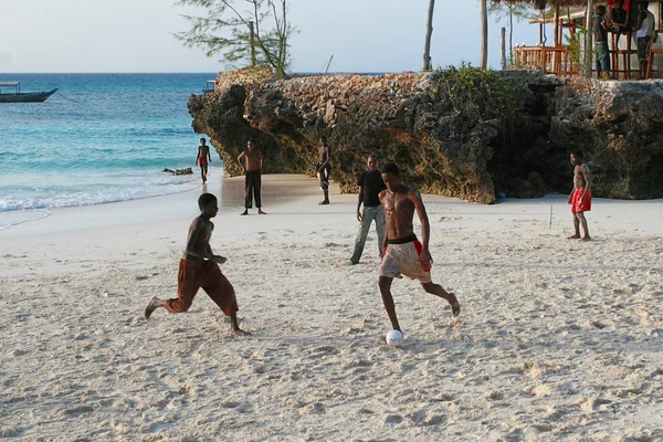 African teens playing beach football on the banks Indian Ocean.