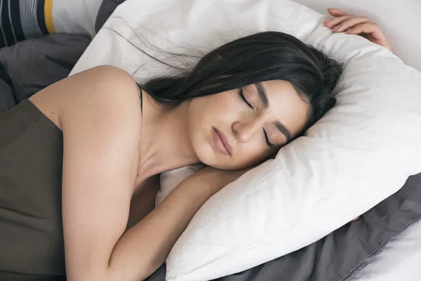 Beautiful Armenian girl sleeping on pillow in morning light