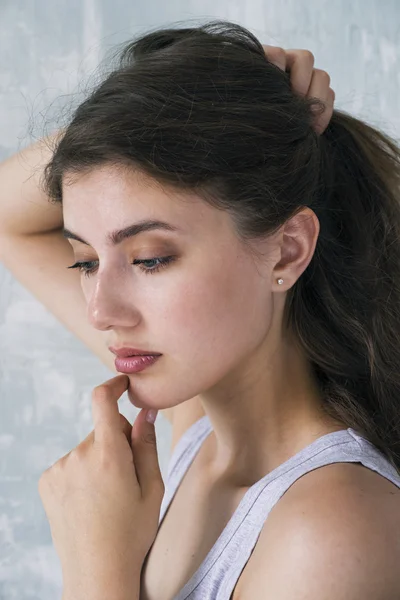 Close-up of sensual model holding her wavy hair in hand