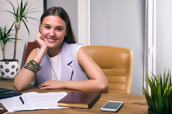 Cheerful girl at desk in office