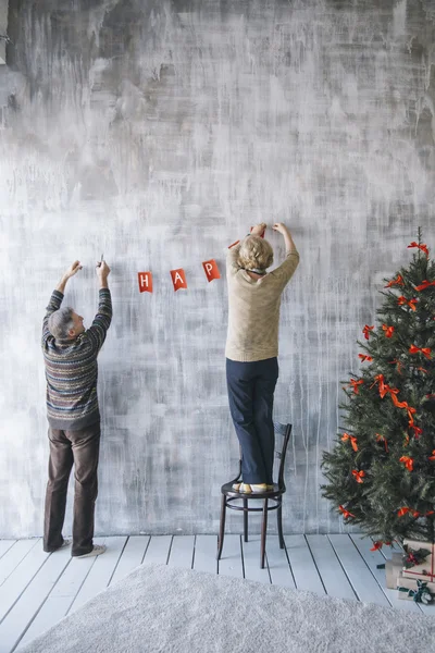 Two people decorating the wall