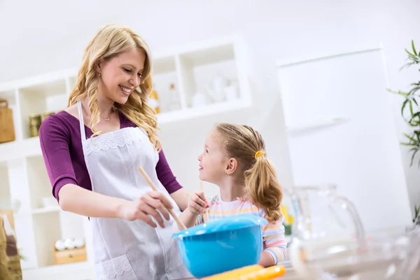 Mother teaching child how to baking bread