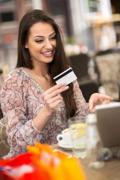 Young girl holding credit card and shopping online