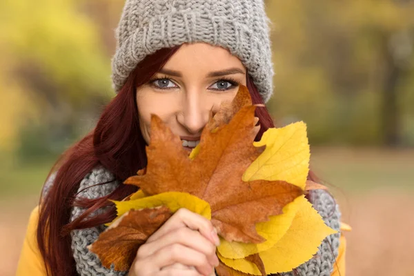 Beautiful smile girl hidden behind the leaves