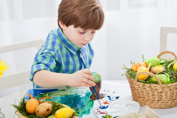 The day before Easter, beautiful child painting eggs for easter