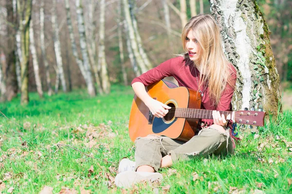 Blonde girl plays guitar
