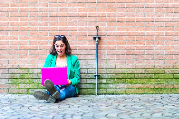 Young student beautiful girl sitting on the ground chat on socia