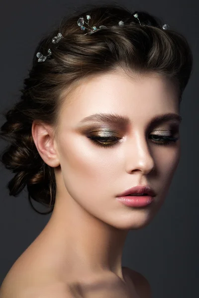 Portrait of young beautiful woman with bridal makeup and coiffur