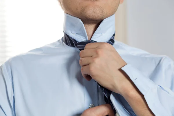 Handsome businessman preparing to official event, straighten tie