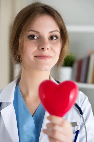Female medicine doctor hold in hands red heart