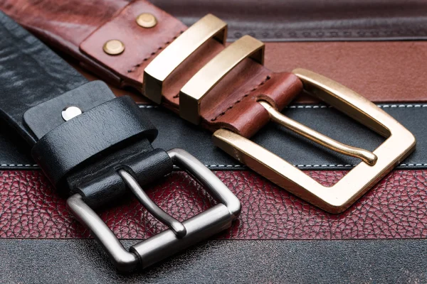 Close-up of two men belts