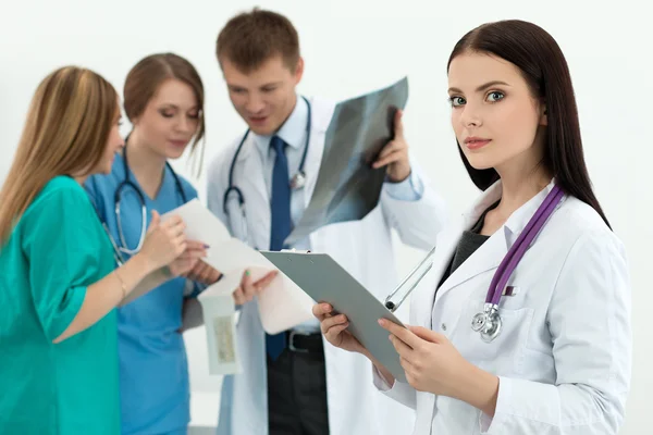 Portrait of brunette female medicine doctor with her colleagues