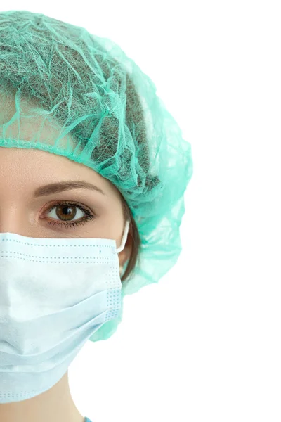 Young woman doctor in cap and face mask close-up portrait