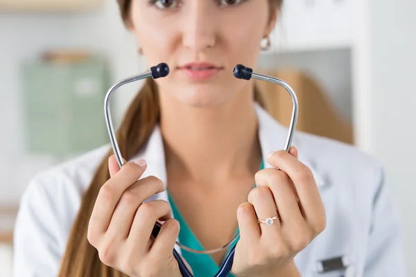 Close-up of female medicine doctor\'s hands holding stethoscope c