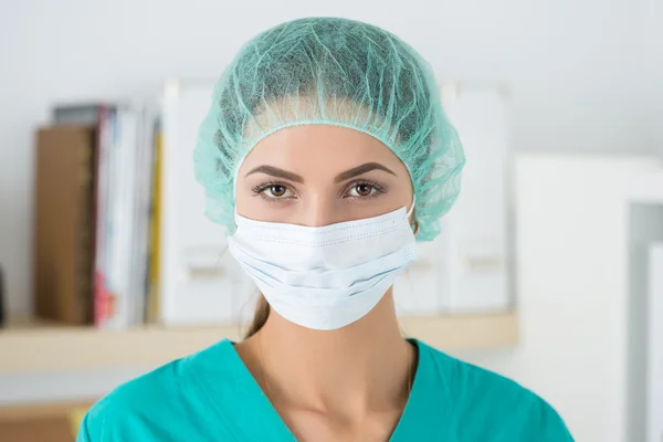 Portrait of female surgeon wearing protective mask and cup