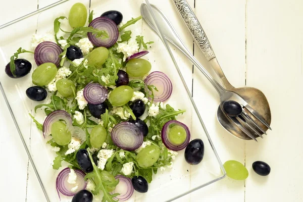 Salad with various grapes, goat cheese, purple onion, arugula