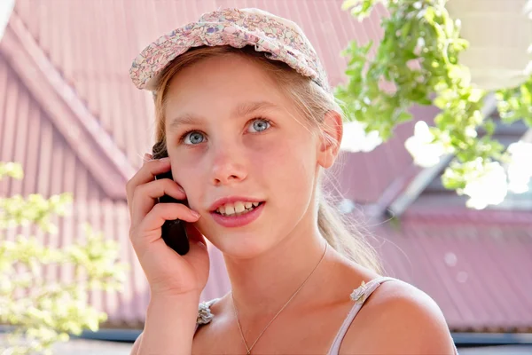 Happy teenage girl talks on phone