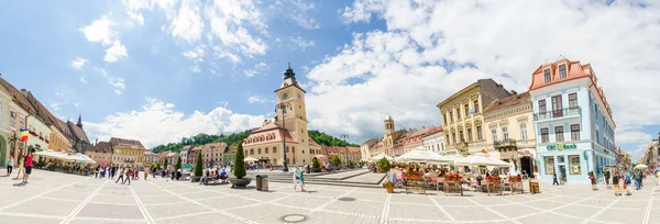 Brasov Sfatului (Council) Square  with lots of tourists on a bright sunny day