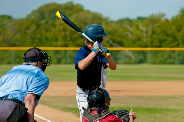 Teenage baseball player batting.