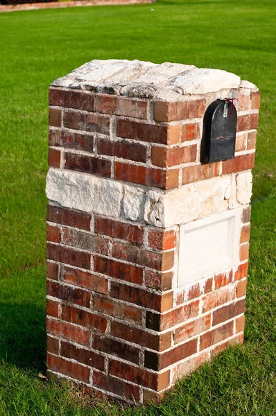 Red Brick mailbox with green grass in background.