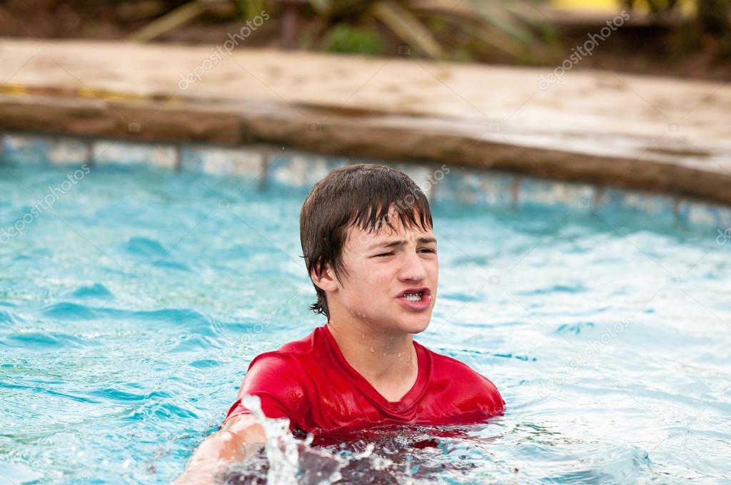 Teen boy in swimming pool with lips puckered. ??? Stock Photo