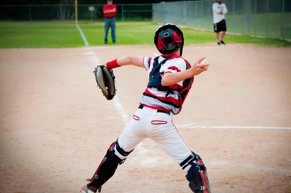 Youth baseball catcher throwing to second base.