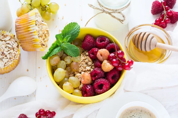 Healthy breakfast: muesli, honey, yogurt, muffins, coffee and fresh berries