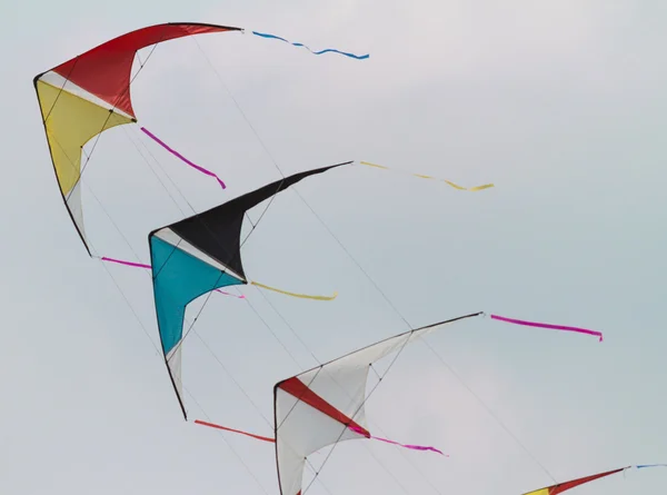 Colorful kites flying  in single file in the sky