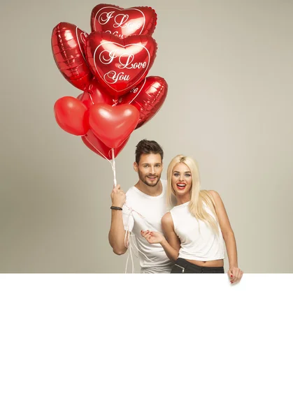 Attractive couple with red balloons
