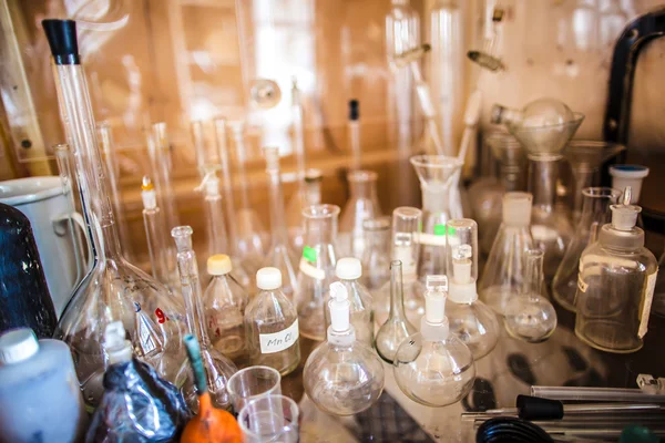 Glass bottles, test tubes, flasks and cups in an old chemical laboratory