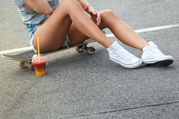 Female legs with  skateboard and smoothie