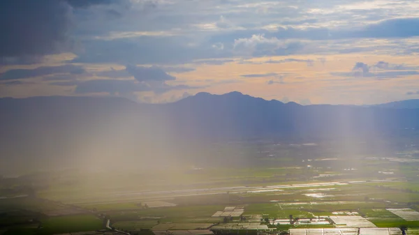 Rain curtaining a view of the mountains.