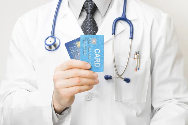Doctor holding credit cards in his hand - closeup studio shot