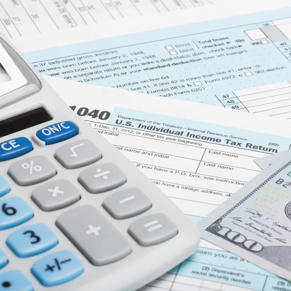 US Tax Form 1040 with calculator and US dollars - 1 to 1 ratio