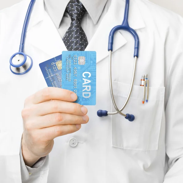 Medocal doctor holding credit cards in his hand - 1 to 1 ratio