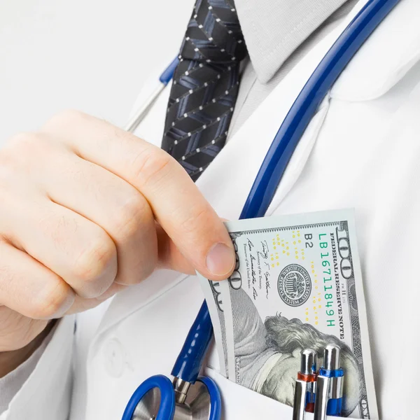 Doctor trying to put money into his pocket - studio shoot - 1 to 1 ratio