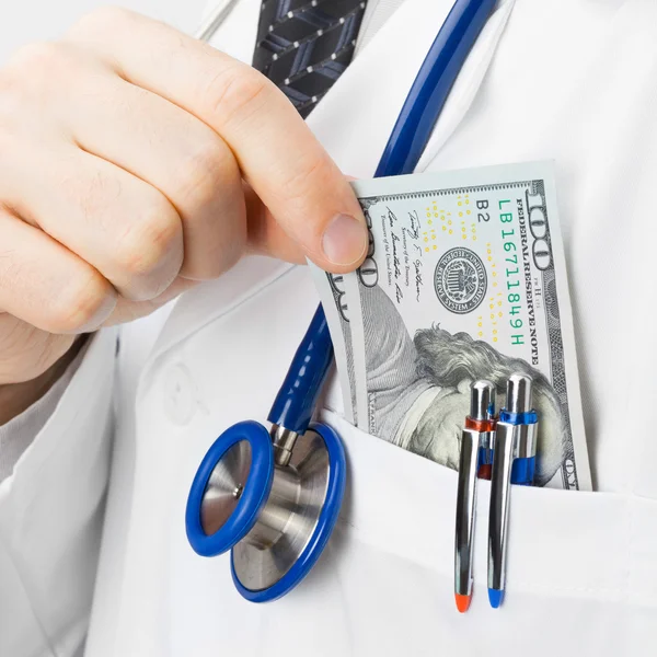 Doctor putting money into his pocket - health care concept