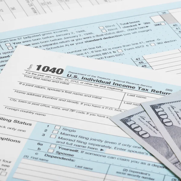 Hundred dollars with US 1040 Tax Form
