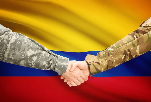 Men in uniform shaking hands with flag on background - Colombia