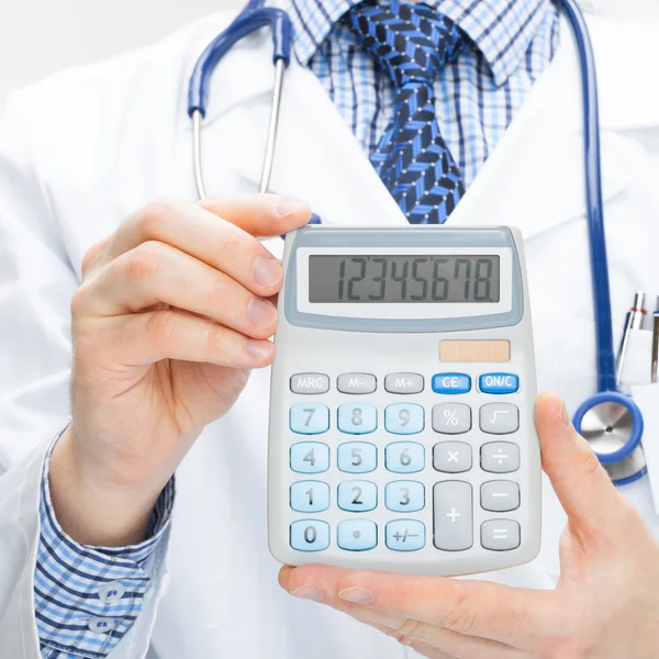 Doctor holding calculator in hands - close up