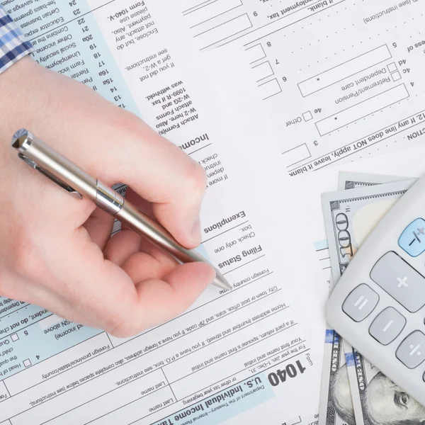 Taxpayer filling out USA 1040 Tax Form - close up